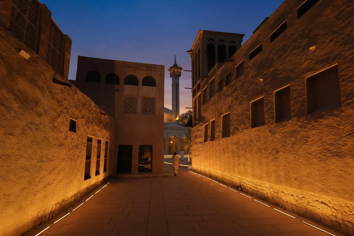 Al Shindagha historic waterfront at night, lit with warm light along Dubai Creek